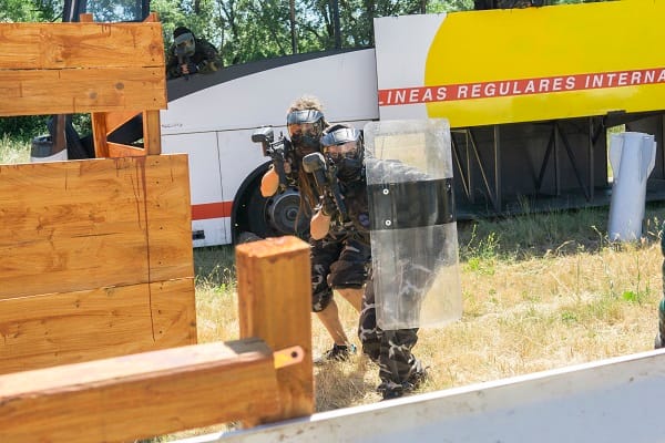 dos jugadores avanzan escondidos tras el escudo
