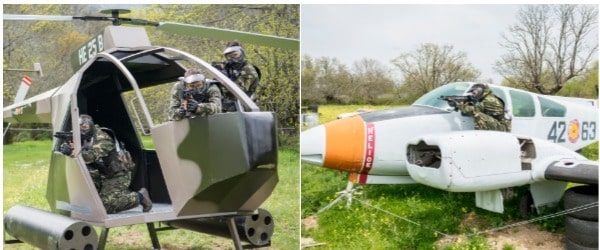 Clientes jugando al paintball con ropa de invierno debajo de los monos de camuflaje en el campo de la tercera guerra mundial